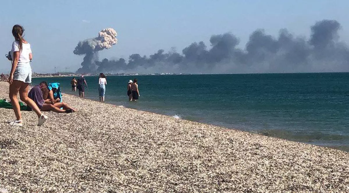 Imagini din momentul exploziilor de la baza militară rusă din Crimeea. Turiștii care stăteau la plajă, înspăimântați de norii groși de fum
