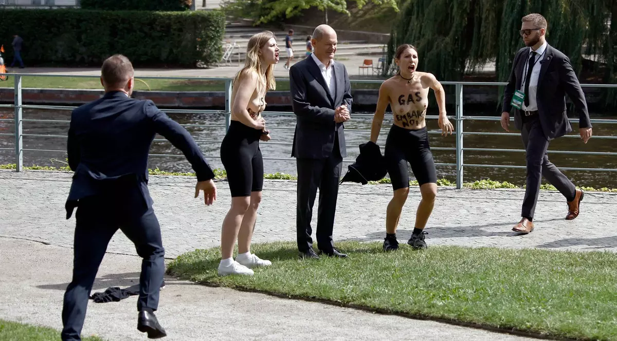 Olaf Scholz, surprins de două militante pentru interzicerea gazului rusesc. S-au dezbrăcat și au făcut o poză alături de el