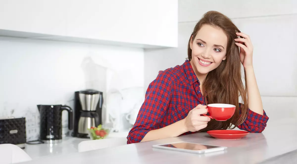 Reduceri importante în Săptămâna Internațională a Cafelei, în oferta Flanco de azi, 29 spetembrie - Imegine cu o tânără care bea cafea într-o bucătărie