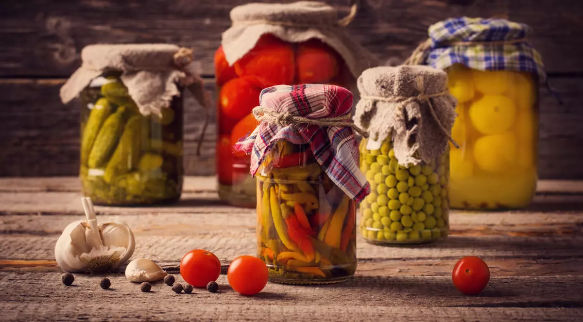 Ce borcane îți trebuie ca să pui murături și conserve - Imagine cu borcane cu conserve de toamnă puse pe o masă de lemn