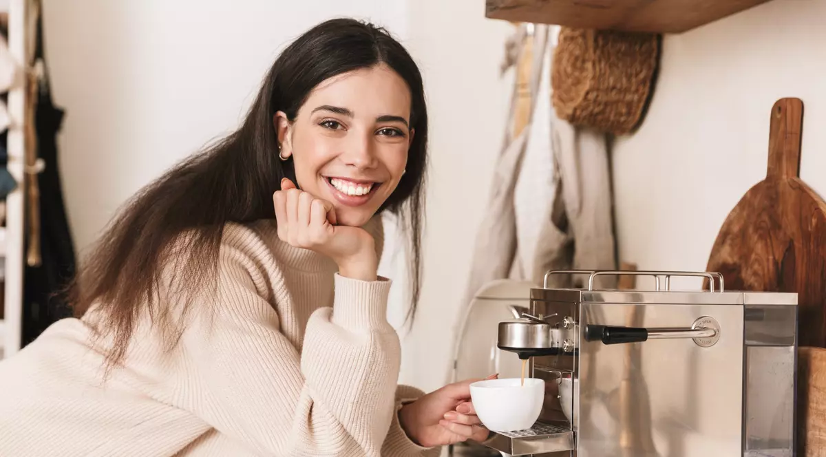 Reduceri importante cu ocazia Lunii cafelei, în oferta Melitta de azi, 13 octombrie - Imagine cu o tânără care îşi prepară o cafea la un espressor