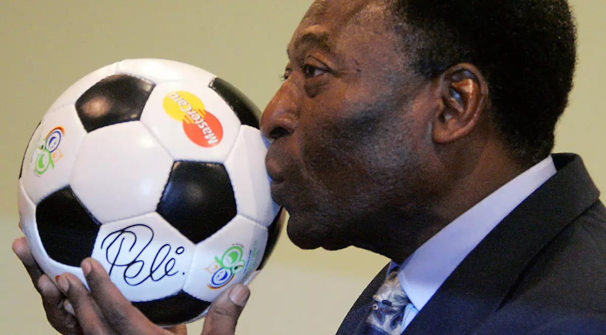 Legenda fotbalului Pele sărută o minge de fotbal la o conferință de presă la Leipzig cu ocazia premierei germane a filmului autobiografic „Pele forever”. Foto: Hepta