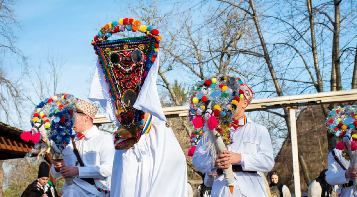Un grup de colindatori, imbracati in haine albe traditionale