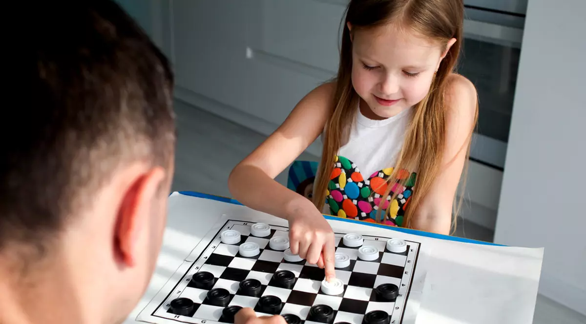 Cum se joacă Dame - Imagine cu un tată şi fiica lui jucând Dame