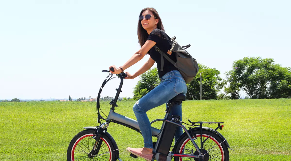 Cum să-ţi alegi bicicleta electrică potrivită - Imagine cu o tânără pe o bicicletă electrică