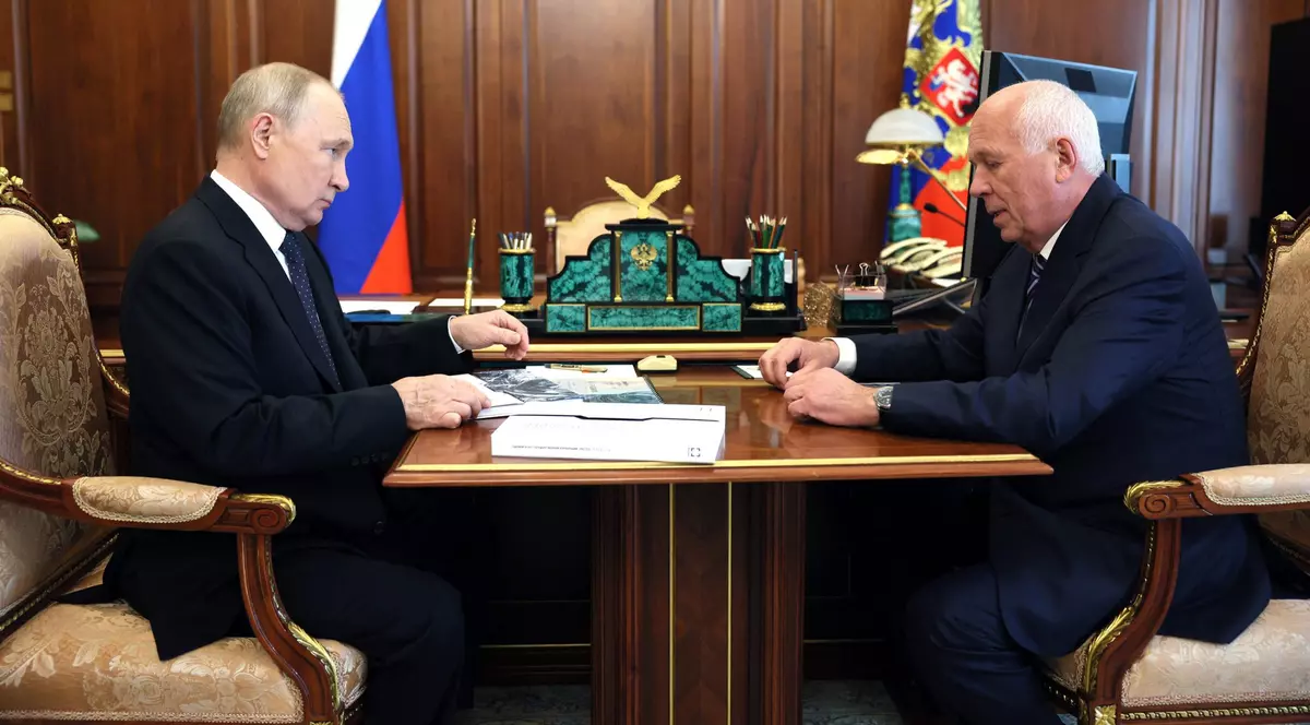 Vladimir Putin și CEO-ul Rostec, Serghei Chemezov, stau la masa si si discuta