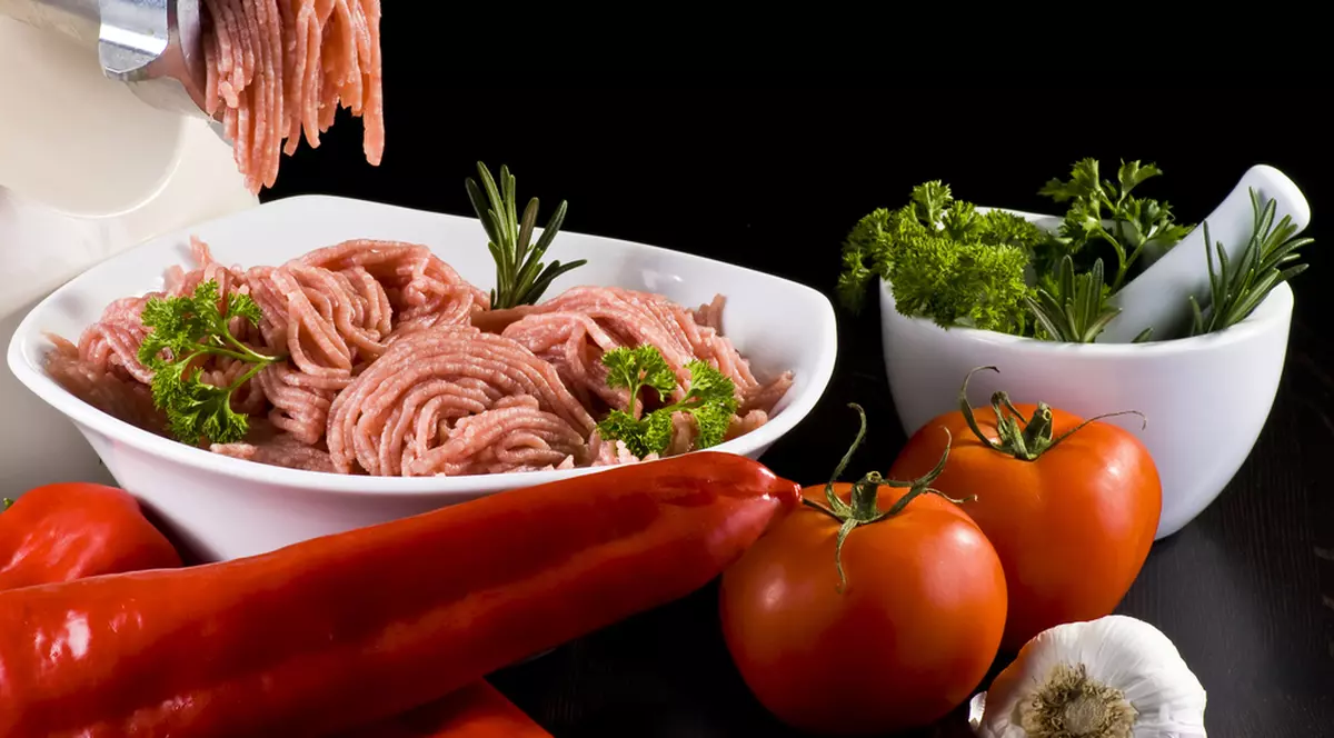Reţetă de ardei umpluţi şi chifteluţe în sos de roşii - Imagine cu un bol cu carne tocată, alături de ardei şi roşii.