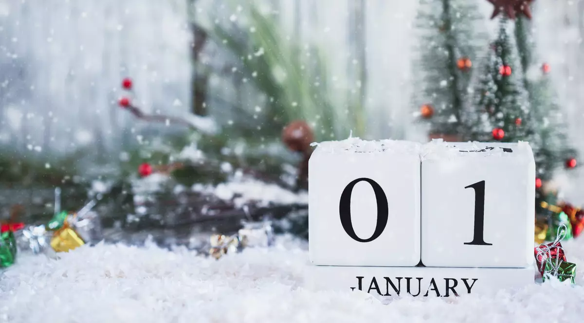 Curiozități despre luna ianuarie - Imagine cu data de 01 ianuarie formată din cuburi albe, pe un fond cu decoraţiuni de iarnă.