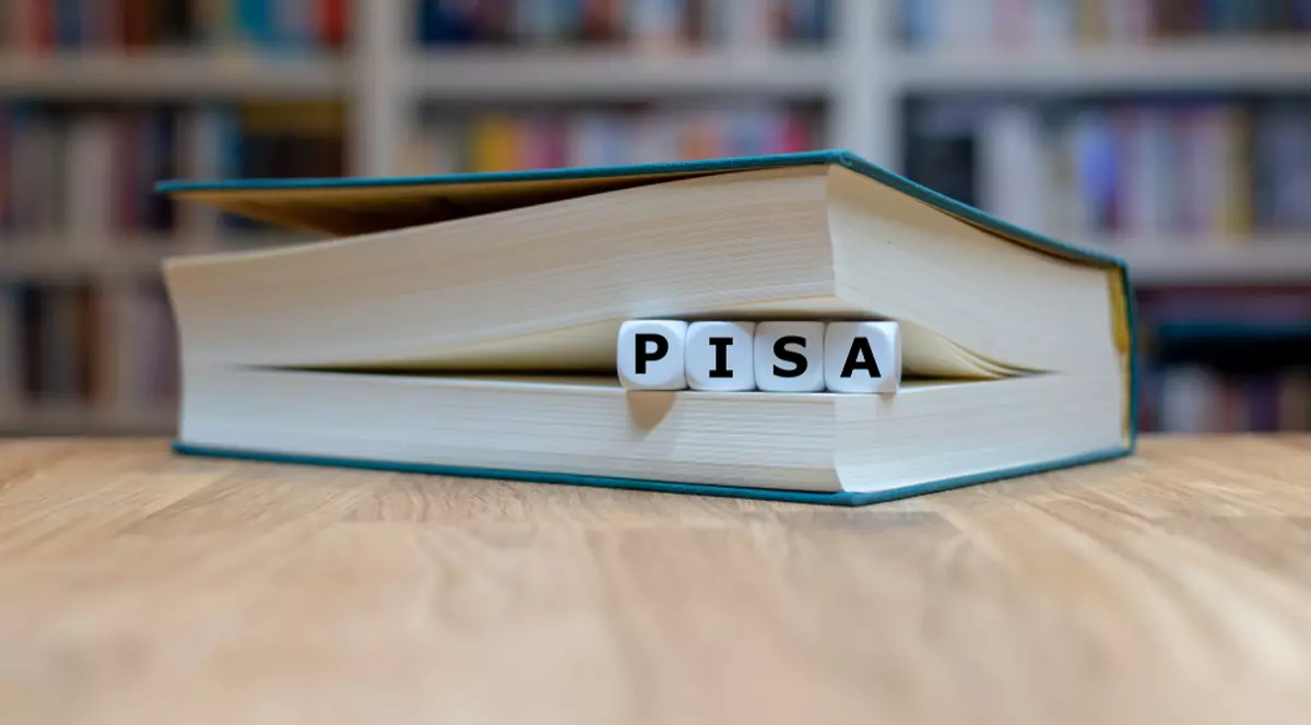 Ce sunt testele Pisa. Modele de teste Pisa - Imagine reprezentând cuvântul PISA, format din cuburi cu câte o literă, aşezat între paginile unei cărţi
