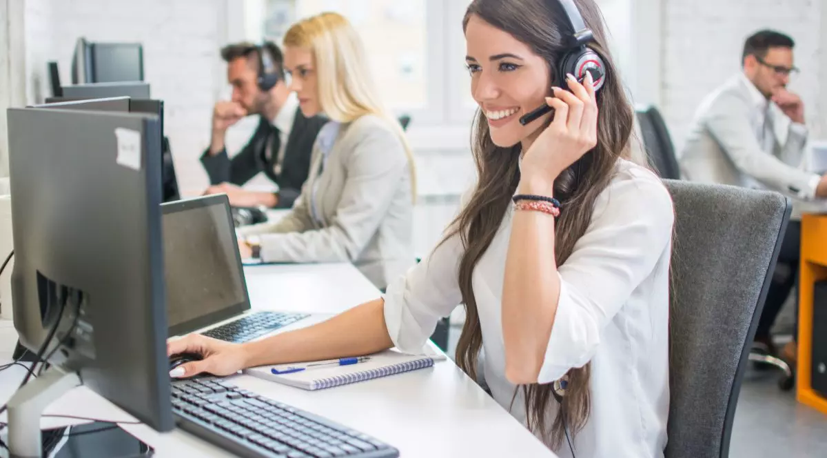 O femeie dintr-un call center cu o pereche de casti pe cap