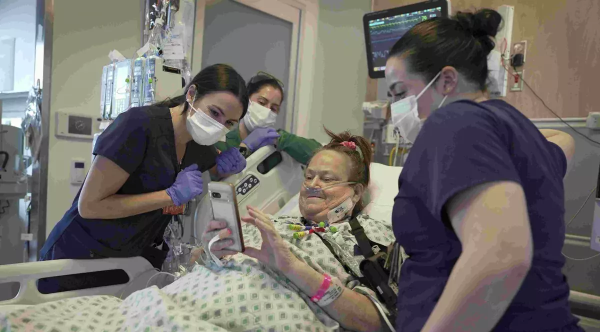 Lisa Pisano se uită la fotografii cu câinele ei după operațiile la NYU Langone Health din New York, luni, 22 aprilie 2024. Medicii i-au transplantat un rinichi de porc lui Pisano, care era aproape de moarte, parte a unei perechi dramatice de operații care au inclus și o soluție pentru inima ei bolnavă. (AP Photo/Shelby Lum). Foto: The Associated Press
