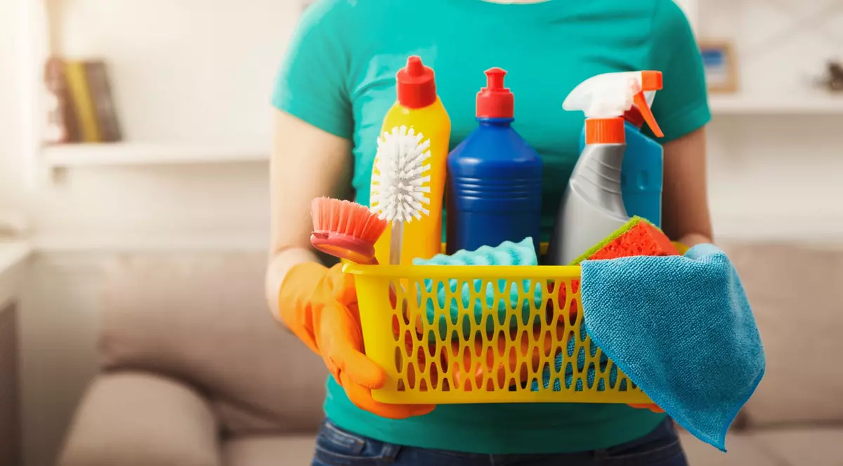 Produse de curăţenie pe care să nu le amesteci niciodată - Imagine cu o persoană care ţine în mâini un coş cu produse de curăţenie