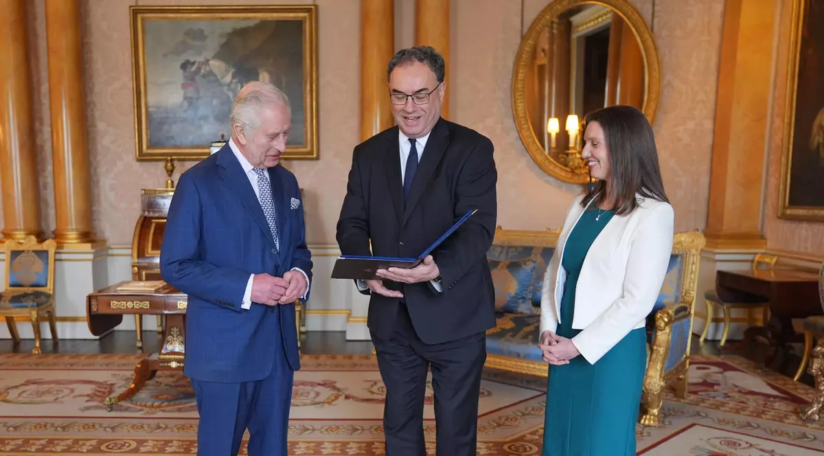 Regele Carol al III-lea (stânga) primește primele bancnote cu portretul său din partea guvernatorului Băncii Angliei, Andrew Bailey, și a lui Sarah John, casierul șef al Băncii Angliei, la Palatul Buckingham din Londra. Foto Facebook / The Royal Family