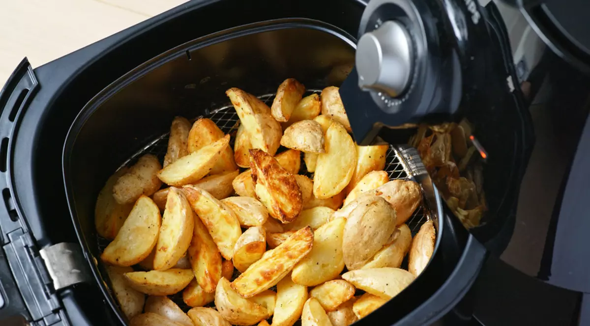 Cât de sănătoase sunt alimentele gătite la friteuza cu aer cald - Imagine cu cartofi prăjiţi în sertarul unui air fryer.