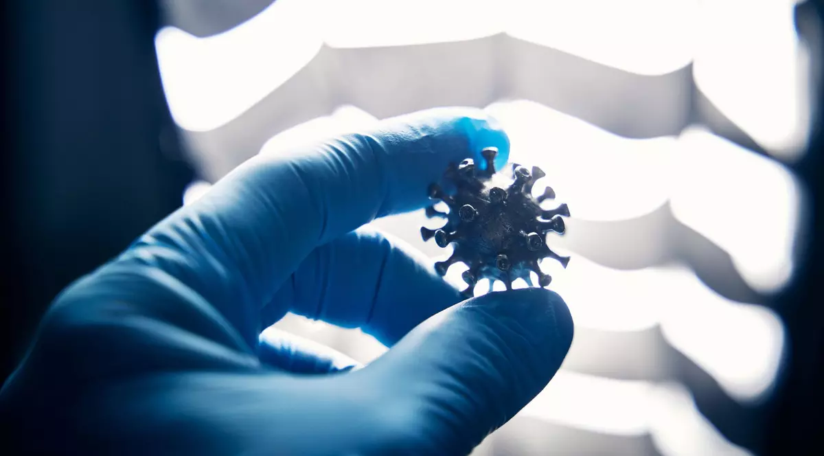 Un cercetător ține în mână un virus