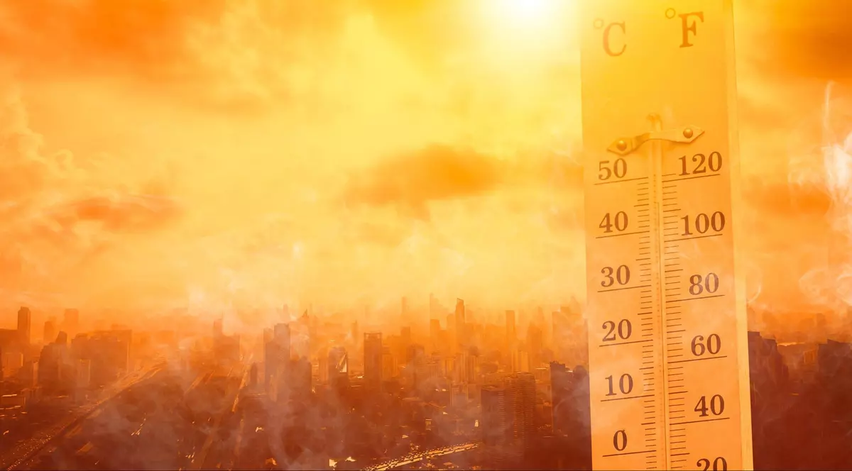 Termometru ce indică o temperatura mare, pe fundal se văd zgârie nori