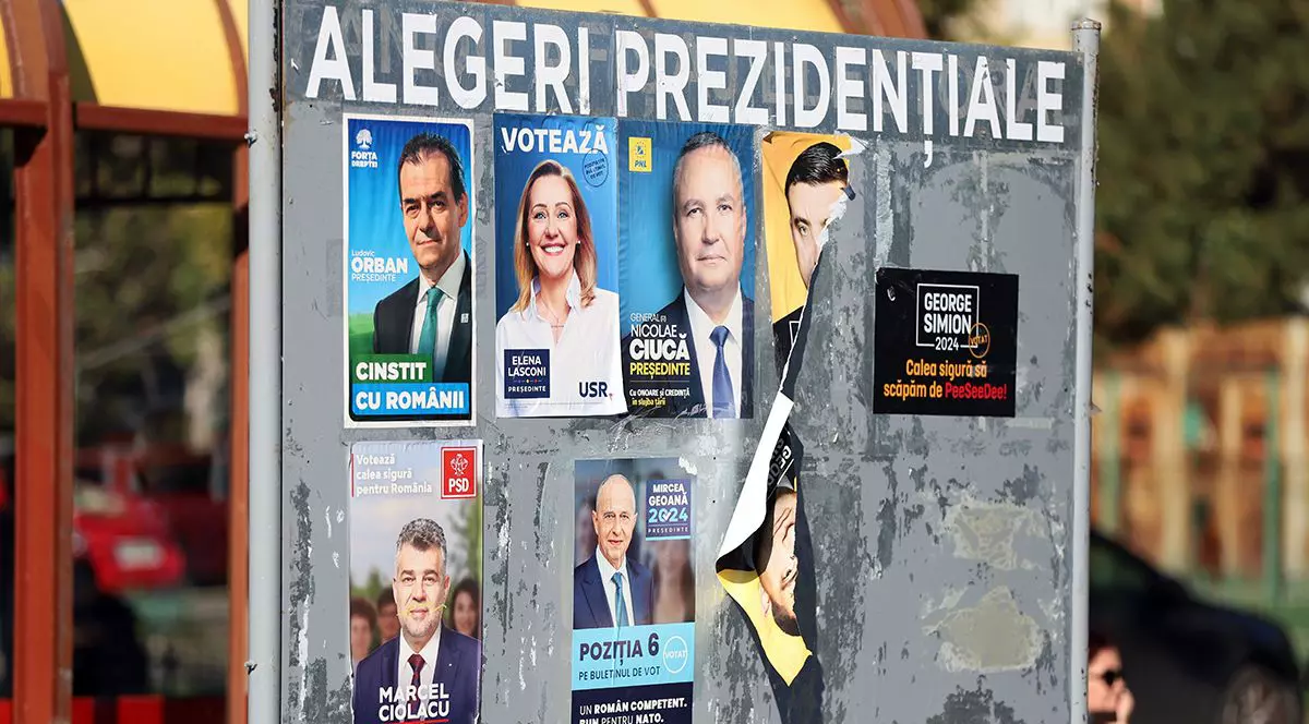 Afișe cu candidații la alegerile prezidențiale din 2024 pe un panoul electoral, pe o stradă din București