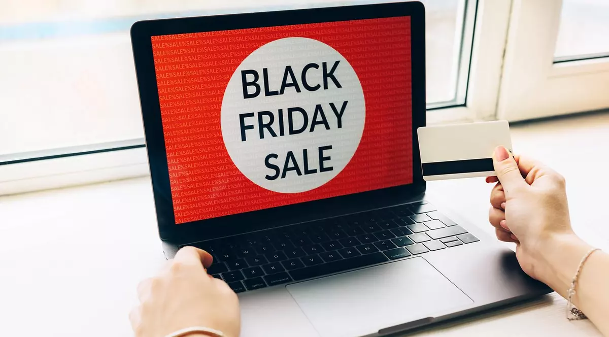 Close-up mâini femeie cu card de credit oferte de Black friday pe laptop
