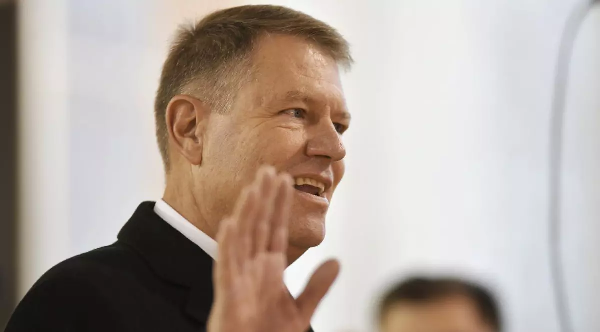 Klaus Iohannis, președintele României, în prim plan, în timp ce face cu mâna, după ce a votat