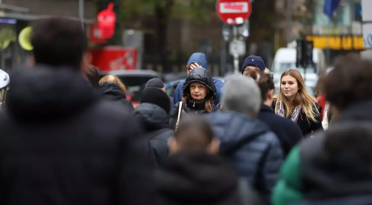 Mai mulți oameni gros îmbrăcați și cu capul acoperit traversează strada, în București. Foto cu caracter ilustrativ: Libertatea/Dumitru Angelescu