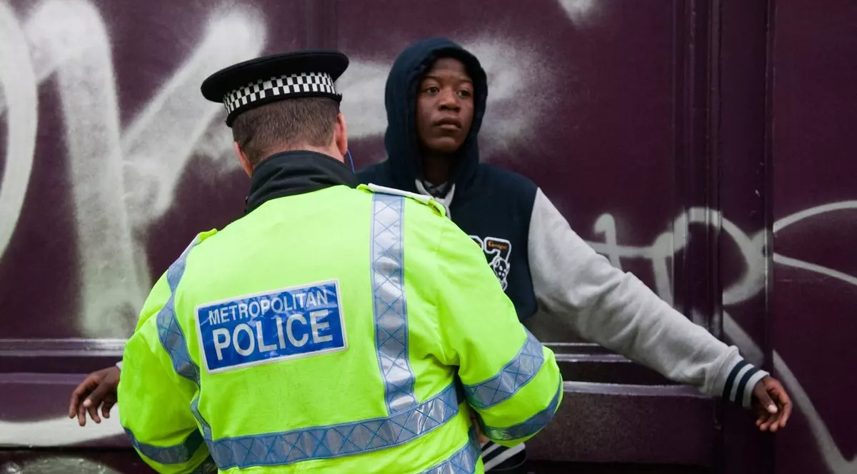 polițist care controlează un tânăr de culoare