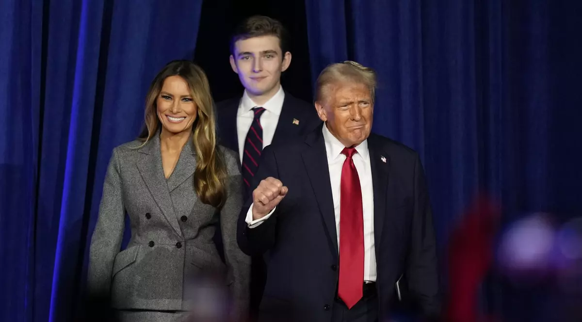 Donald Trump, însoțit de Melania Trump, stânga, și Barron Trump, sosește pentru a vorbi la o petrecere de supraveghere din noaptea alegerilor, miercuri, 6 noiembrie 2024, în West Palm Beach, Florida.