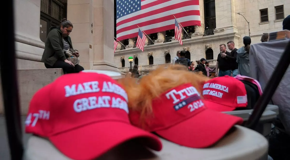 Șepci cu sloganul lui Donald Trump: „Make America Great Again”, vândute la New York, în spate se vede steagul SUA