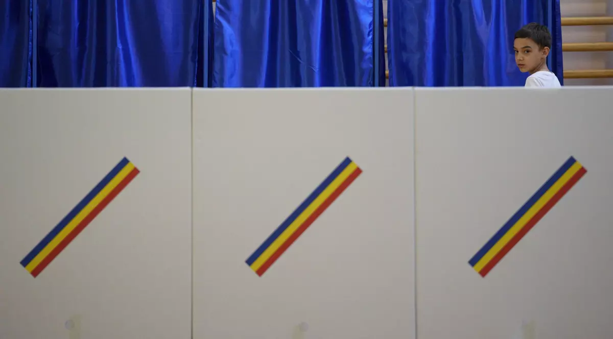 Un copil privește urnele de vot într-o secție de votare din București. Imagine realizată la 9 iunie 2024.