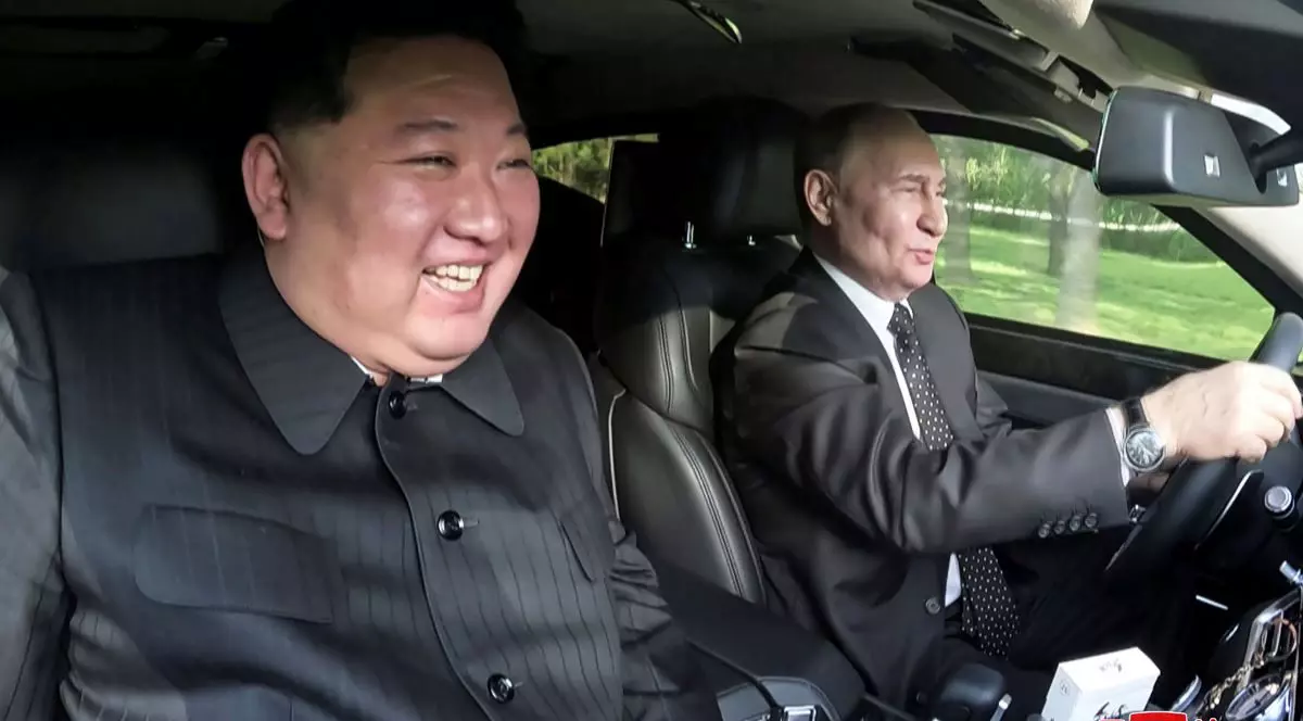 Vladimir Putin și Kim Jong-un cu zâmbetul pe buze, într-o mașină condusă de liderul rus