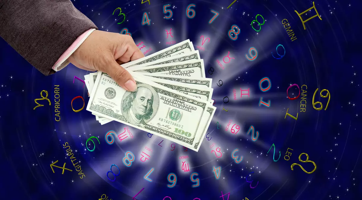 Zodii care au noroc la bani în această iarnă - Imagine cu o mână de bărbat care ţine bani, deasupra unei astrograme