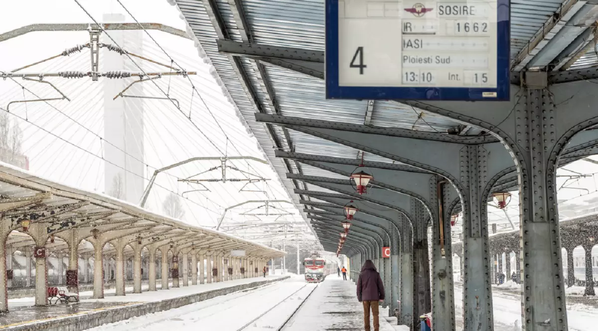 Imagini cu gara din Iași, pe timp de iarna. Un tren ajunge in gara, iar pe peron asteapta cativa oameni