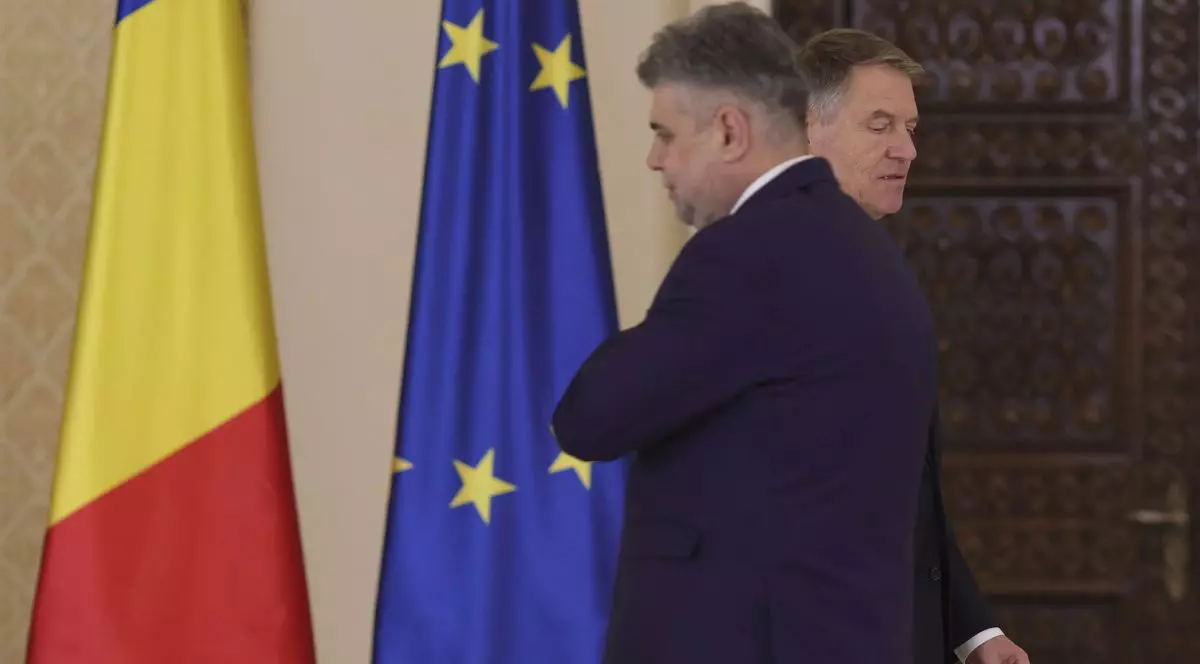 Klaus Iohannis și Marcel Ciolacu, la Palatrul Cotroceni, având pe fundal steagurile României și Uniunii Europene