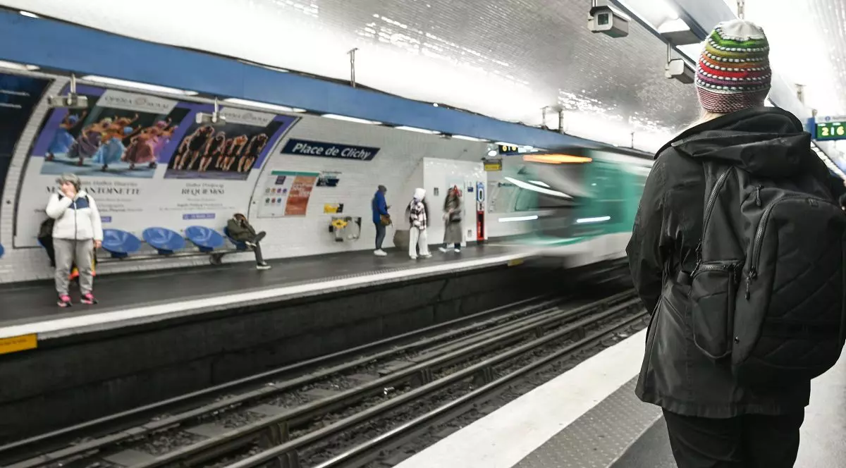 Un tren de metro sosește într-o stație și pe peron sunt mai mulți călători