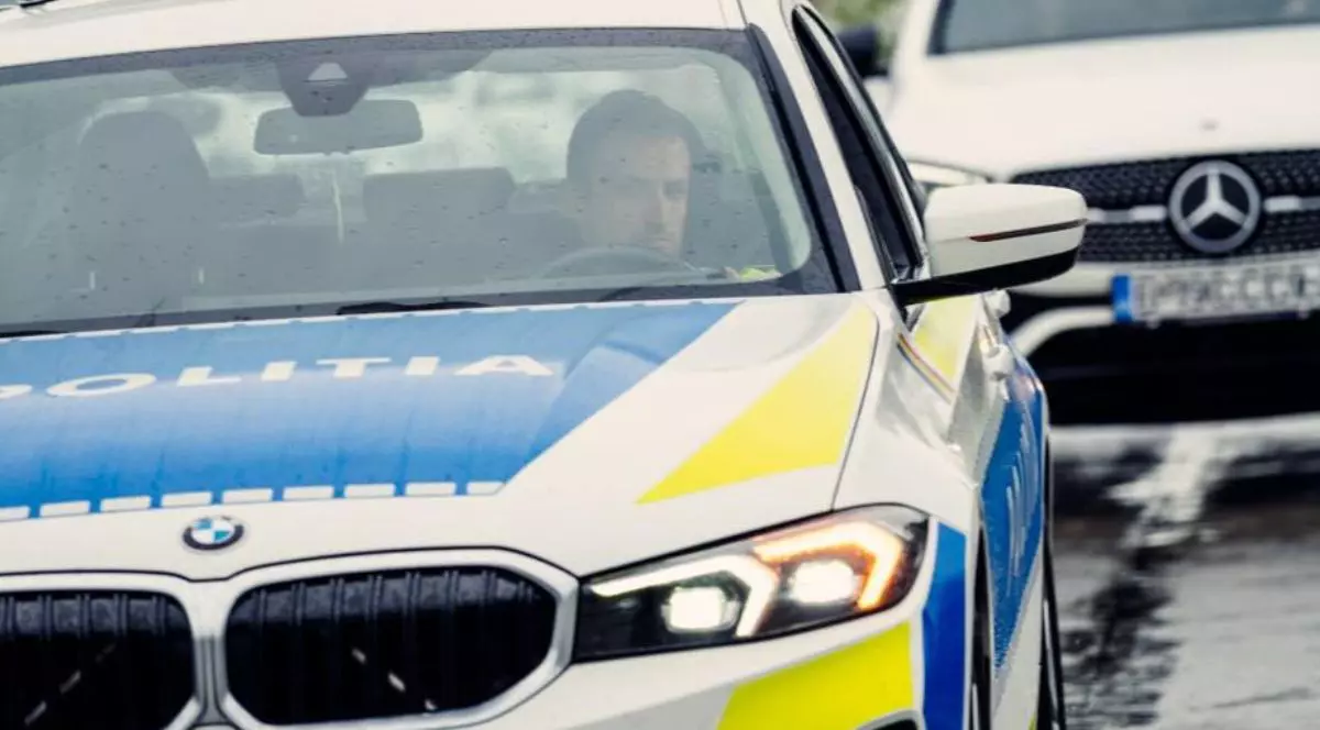 Un BMW al Poliției Rutiere, în prim plan, inscripționat oficial, și în plan secund un Mercedes de culoare albă