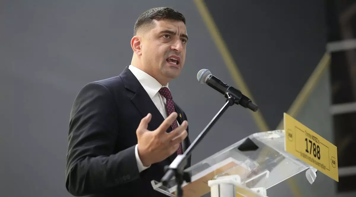 George Simion vorbește în fața unui microfon.