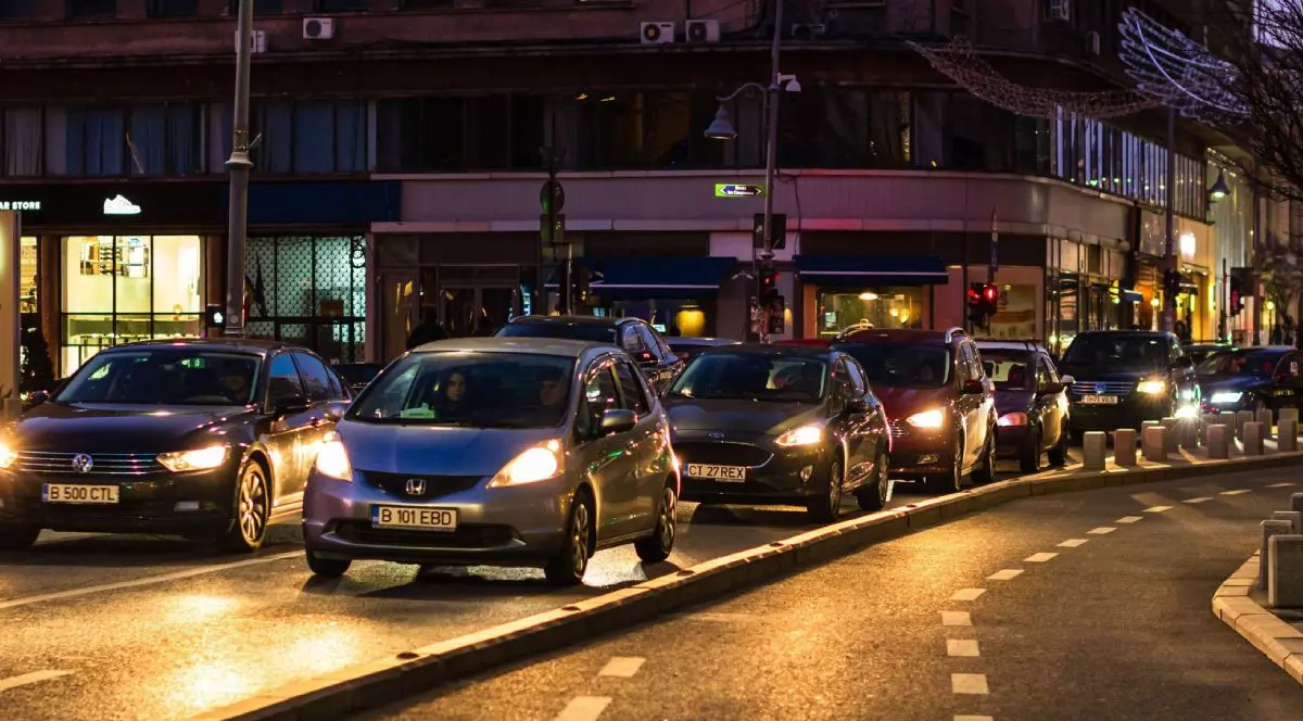 Mașini în traficul din București, noaptea, cu farurile aprinse, în timp ce așteaptă la semafor