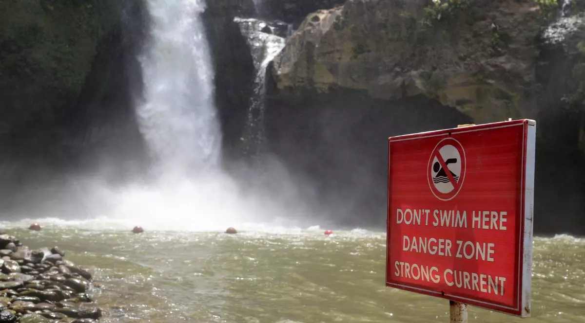 semn de pericol amplasat în fața unei cascade