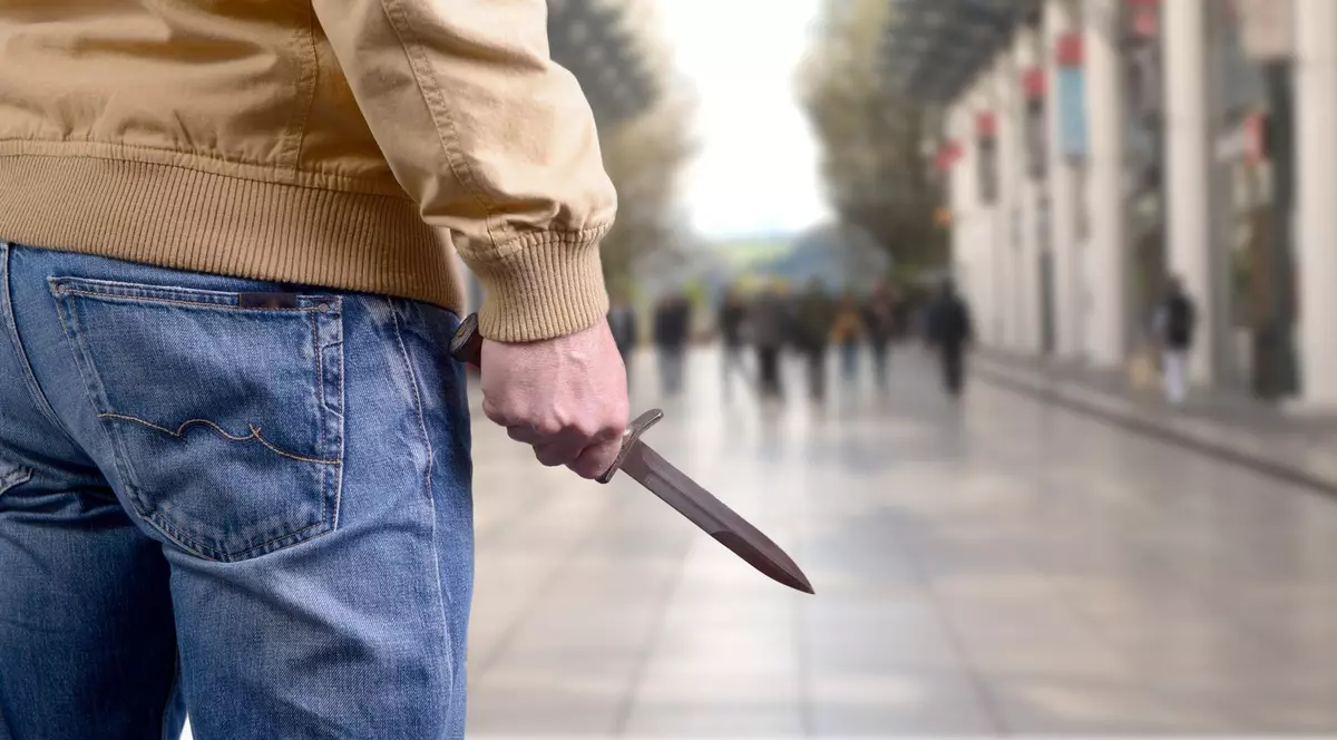 Bărbat care ține în mână un cuțit.