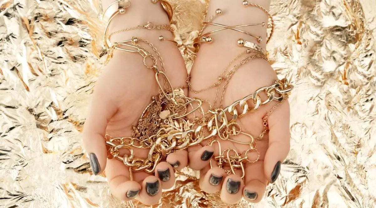 Bijuterii din aur, de mare valoare, ținute în mână de o femeie