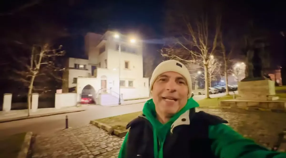 Dan Negru, cu un fes alb în cap, hanorac verde și vestă neagră, vineri, 24 ianuarie 2025, în fața statuii lui Alexandru Ioan Cuza