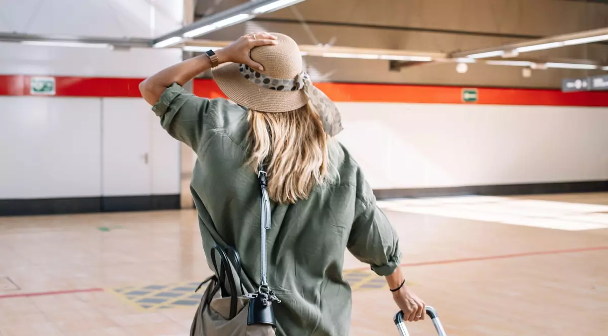 Femeie surprinsă în timp ce trage după ea un bagaj.