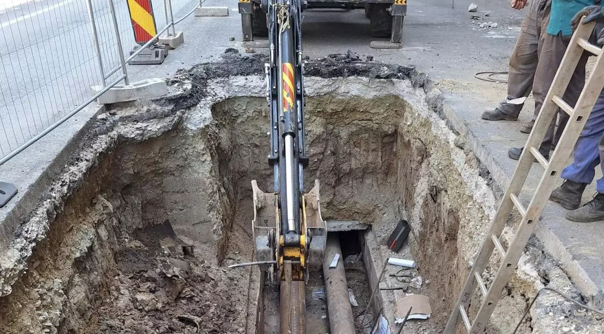 Mai mulți muncitori lucrează la schimbarea unor țevi, după ce a apărut o avarie la conductele de apă caldă