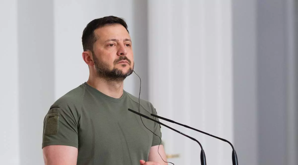 Președintele Ucrainei, Volodimir Zelenski, îmbrăcat cu un tricou verde, în fața unui pupitru cu microfon