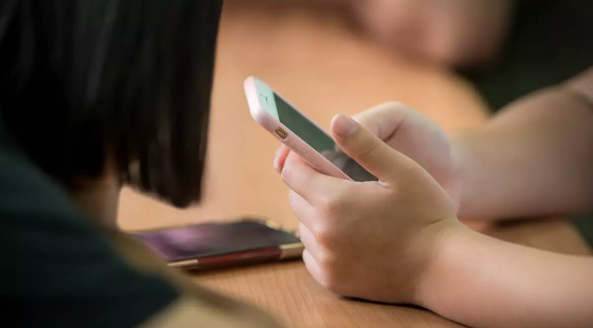 telefon tinut in mana de un adolescent