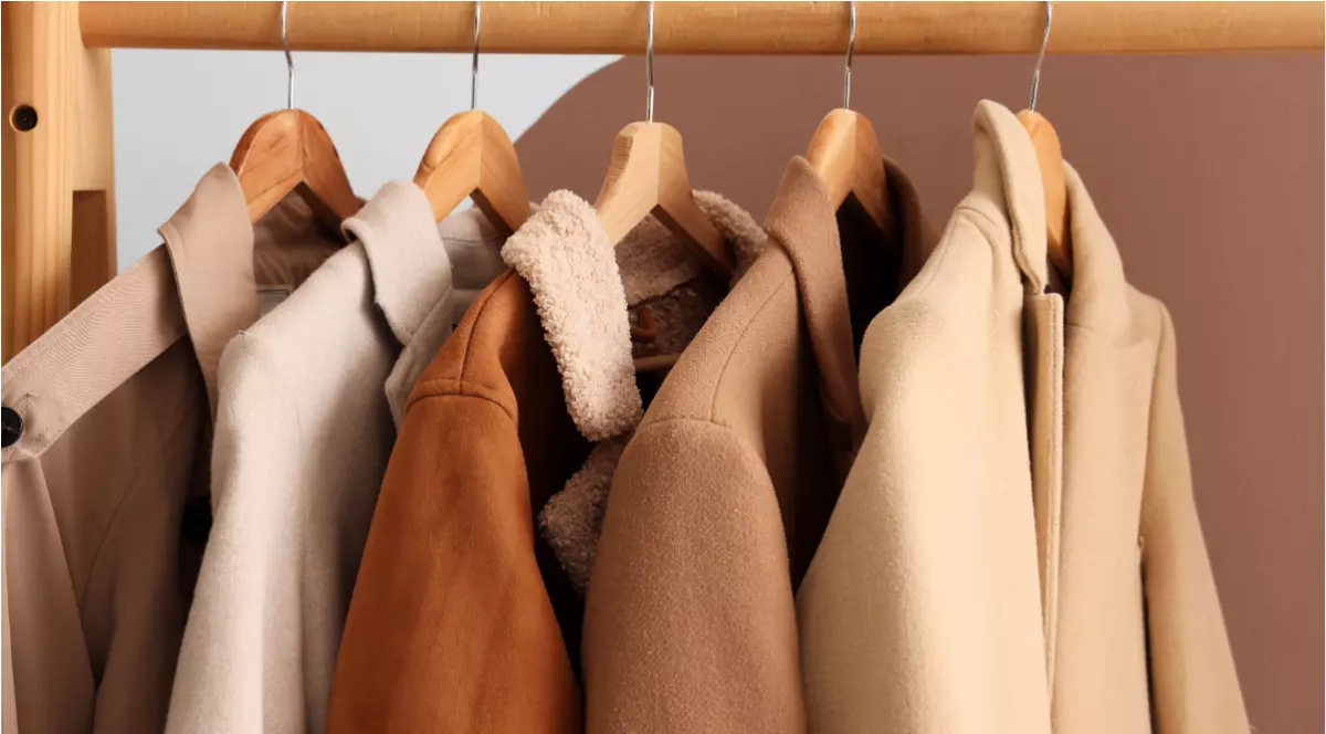 Paltoane de culoare bej, pe umerașe