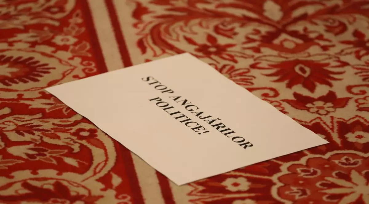 o pancartă cu textul „Stop Angajărilor Politice”pe podeaua Camerei Deputaților