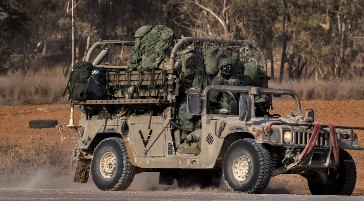 Soldați înarmați într-un Humvee se îndreaptă spre un obiectiv