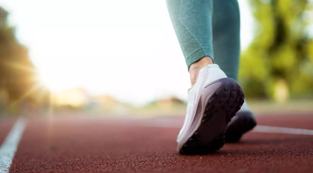 picioarele unei femei cu colanti verzi pe o pista de alergare