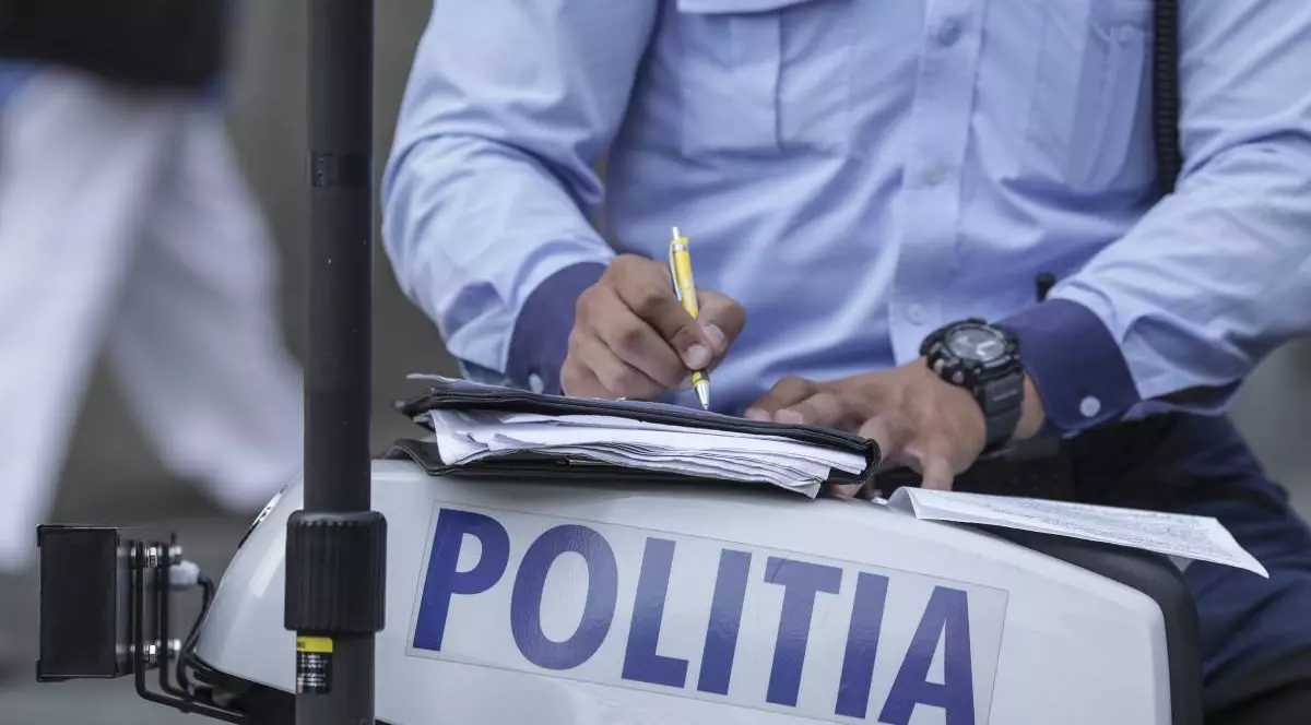 politist in timp ce scrie o amenda rutiera