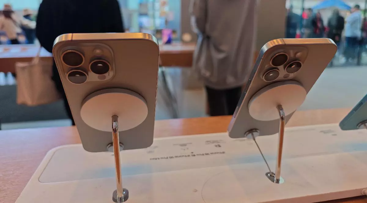 Două telefoane gri din seria iPhone 16 sunt așezate pe standuri de prezentare într-un magazin Apple din Shanghai, China.